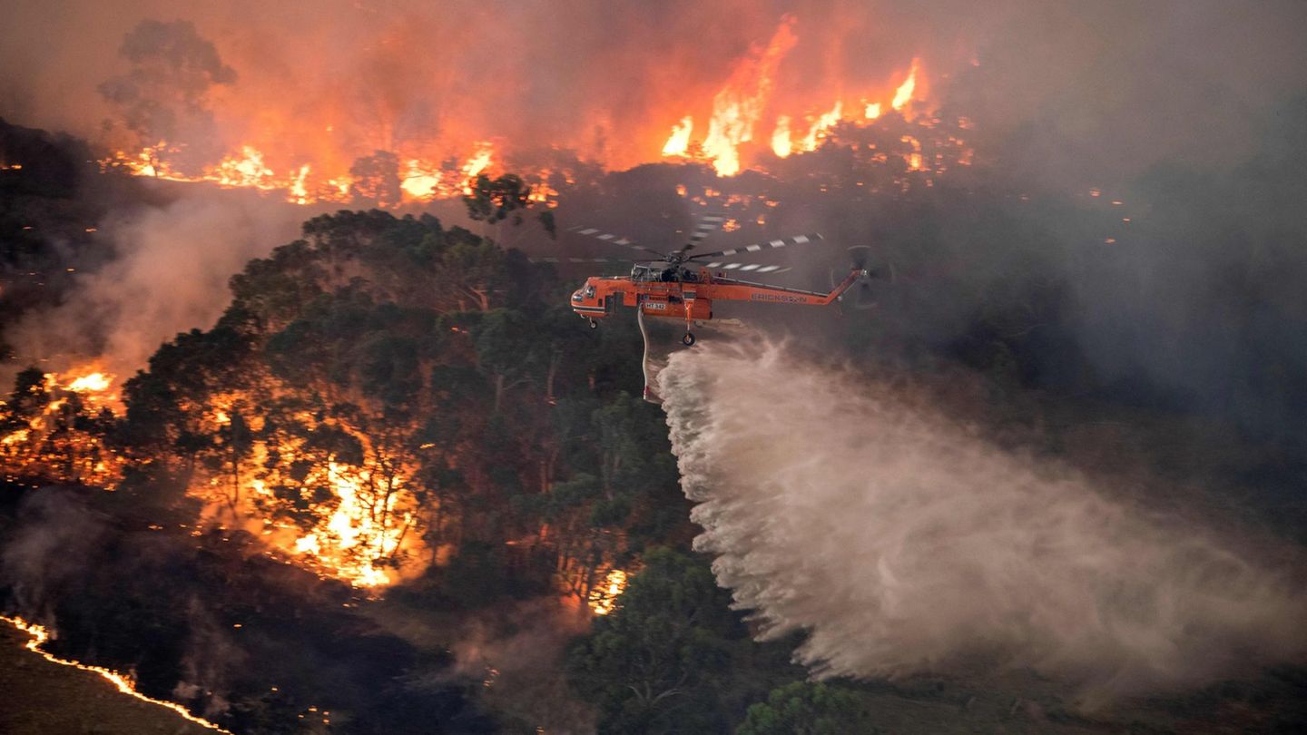 A handout photo taken and received on December 31, 2019 from the State Government of Victoria shows a helicopter fighting a bushfire near Bairnsdale in Victoria's East Gippsland region. - Thousands of holidaymakers and locals were forced to flee to... Ein Hubschrauber über dem Flammenmeer