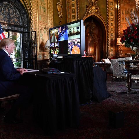 Trump vor einem großen Bildschirm