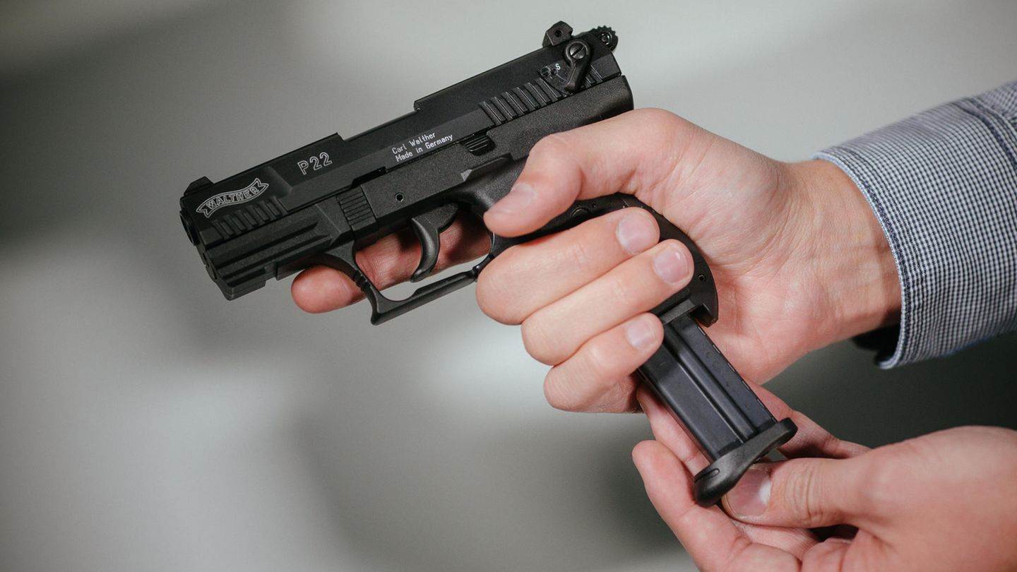 Hände laden eine Schreckschuss-Pistole «Walther P22» mit einem Magazin