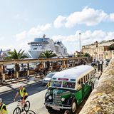 Im Hintergrund: die MSC Grandiosa. Im Vordergrund: Eine befahrene Straße