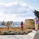 Touristen machen Urlaubsfotos am Hafen von Valletta