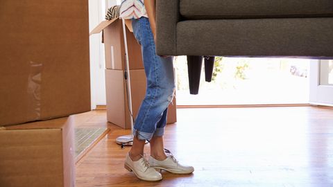 Eine junge Frau trägt Kisten in eine Wohnung