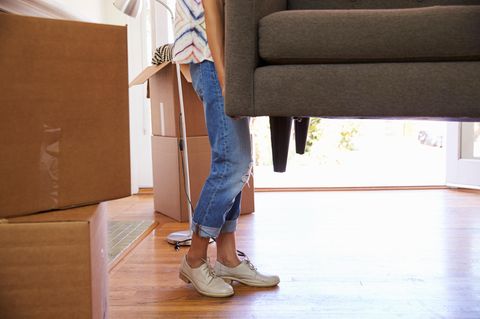 Eine junge Frau trägt Kisten in eine Wohnung