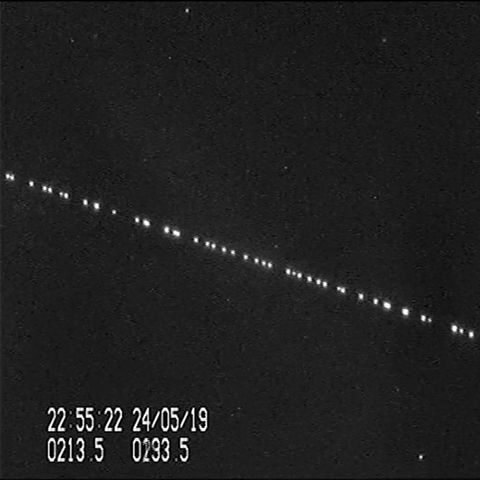 Helle Punkte ziehen in einer Reihe über den Sternenhimmel
