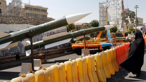Eine Iranerin schaut sich mehrere ausgestellte Taer-2-Raketen an