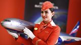 Flugbegleiterin von Aeroflot mit Flugzeugmodell
