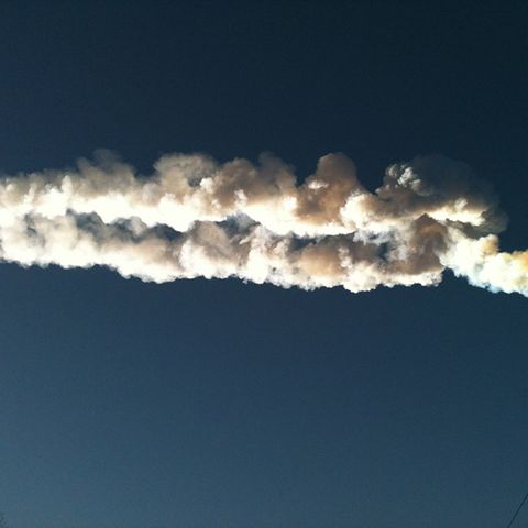 Ein Meteorit hinterlässt am Himmel über der Stadt eine weiße Spur