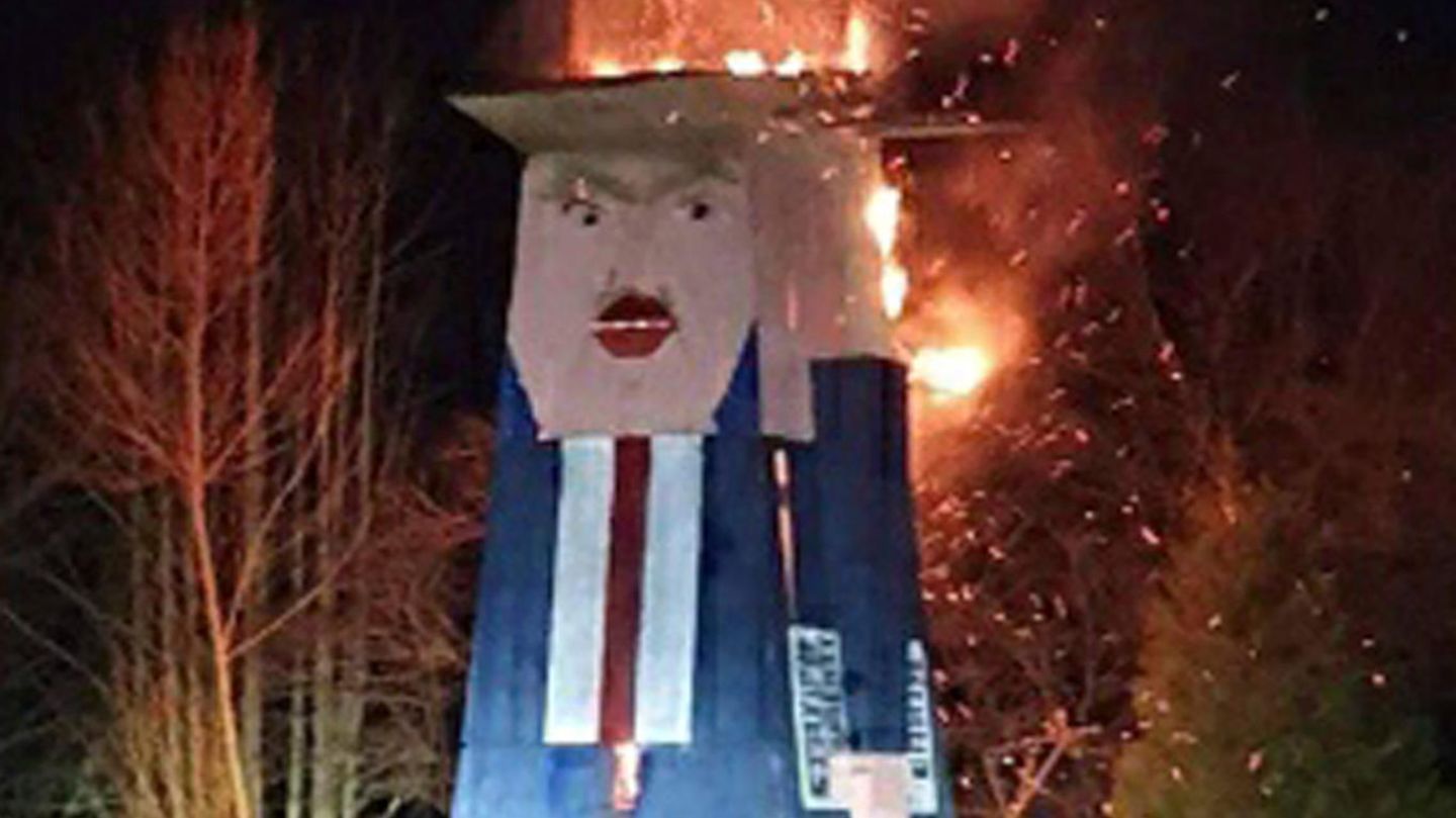 Slowenien, Moravce: Eine Holzstatue, die den US-Präsidenten Trump mit erhobenem Arm darstellt, brennt