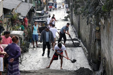 Philippinen, Cavite: Anwohner reinigen eine Straße von Asche