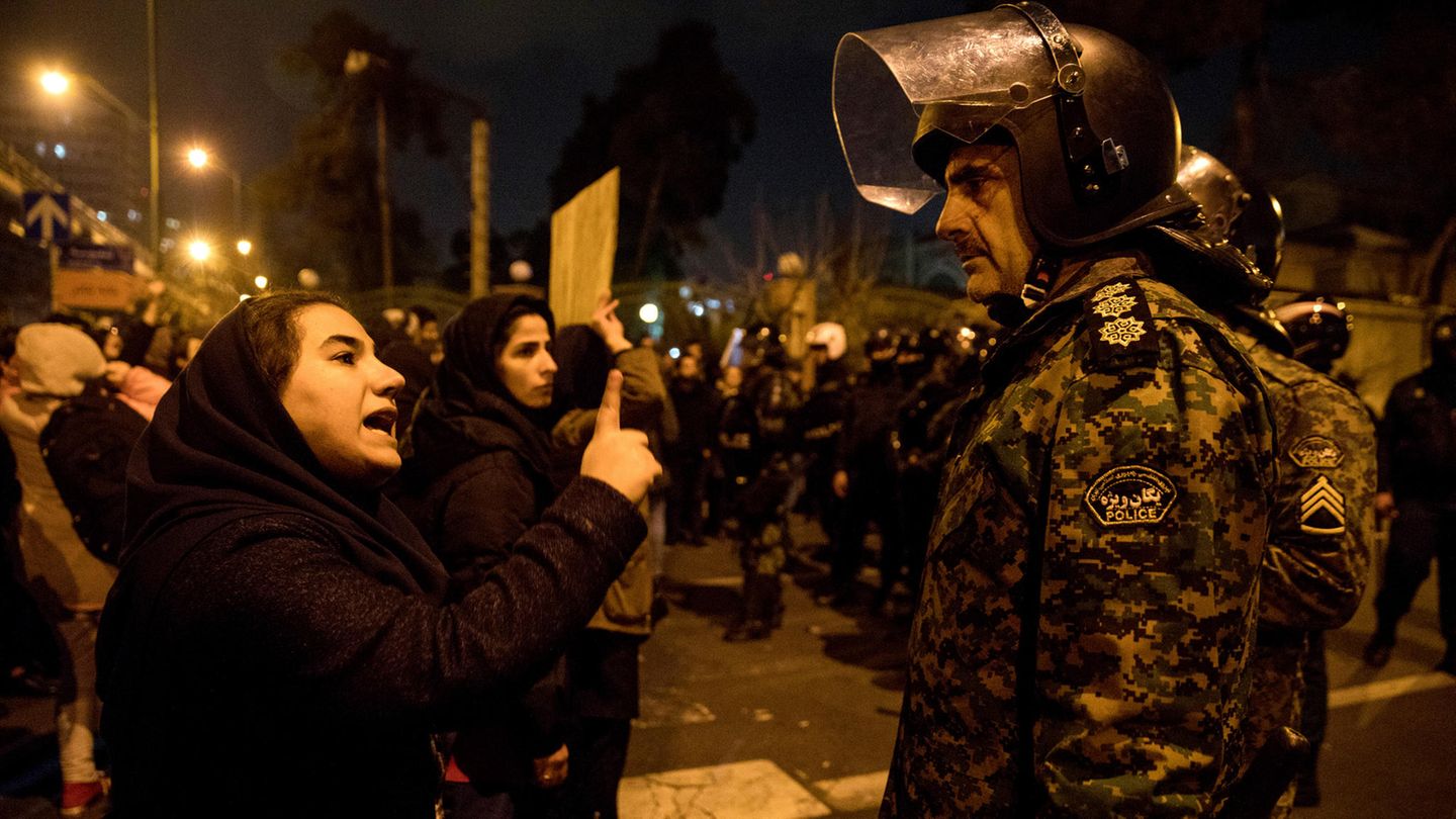 Iran, Teheran: Eine Frau spricht im Rahmen einer Nachtwache mit einem Polizisten