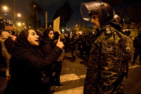 Iran, Teheran: Eine Frau spricht im Rahmen einer Nachtwache mit einem Polizisten