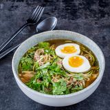 Low-Carb-Ramen-Suppe      Für 4 Personen   800 g Hähnchenbrustfilets mit Haut  Salz  4 Zwiebeln  800 g Zucchini  2-3 EL Sojasauce  frisch gemahlener schwarzer Pfeffer  4 Eier (Größe M)  1 Bund Koriandergrün  Zubereitungszeit 20 Min + 30 Min Ruhezeit + 2h Garzeit      Zubereitung  • Die Hähnchenbrustfilets etwa 30 Minuten vor der Zubereitung aus dem Kühlschrank nehmen. Dann leicht salzen und in einen großen Topf legen. Die Zwiebeln abziehen, in Streifen schneiden und auf die Filets legen. So viel Wasser angießen, dass Fleisch und Zwiebeln gerade damit bedeckt sind. Langsam zum Köcheln bringen, dann bei schwacher Hitze 2–2 ½ Stunden im offenen Topf köcheln lassen.  • Die Hähnchenbrustfilets anschließend aus der Brühe nehmen, die Haut entsorgen und das Fleisch mithilfe von zwei Gabeln fein zerzupfen. Die Brühe durch ein Sieb passieren und das Fleisch wieder dazugeben.  • Die Zucchini waschen, putzen, trocken tupfen und mithilfe eines Spiralschneiders in "Spaghetti" schneiden. In einer Schüssel mit ½ TL Salz vermengen und 10 Minuten ziehen lassen. Die entstandene Flüssigkeit abgießen.  • Dann die Zucchininudeln in die Brühe geben und alles 1-2 Minuten aufköcheln lassen. Die Suppe mit der Sojasauce sowie Salz und Pfeffer abschmecken.  • Die Eier in kochendem Wasser in 6 Minuten wachsweich kochen, abschrecken und pellen.  • Die Suppe auf vier Suppenschalen verteilen und jeweils ein halbiertes Ei daraufsetzen. Den Koriander waschen, trocken schütteln und die Blätter abzupfen. Auf die Suppe geben und das Ei mit etwas Salz bestreuen.      Tipp: Brühe und Hähnchenfleisch lassen sich bereits gut am Vortag zubereiten!      Nährwerte pro Portion: Kcal 322 | E 57 g | F 7 g | KH 5 g