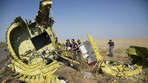 Spezialisten für Flugunfalluntersuchung aus den Niederlanden stehen Anfang August 2014 neben Überresten des Fluges MH17 auf einem Feld bei dem Dorf Hrabove in der östlichen Ukraine.