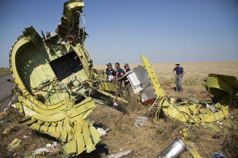 Spezialisten für Flugunfalluntersuchung aus den Niederlanden stehen Anfang August 2014 neben Überresten des Fluges MH17 auf einem Feld bei dem Dorf Hrabove in der östlichen Ukraine.