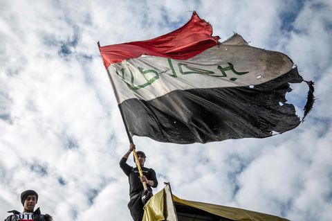 Ein Demonstrant schwenkt die irakische Flagge