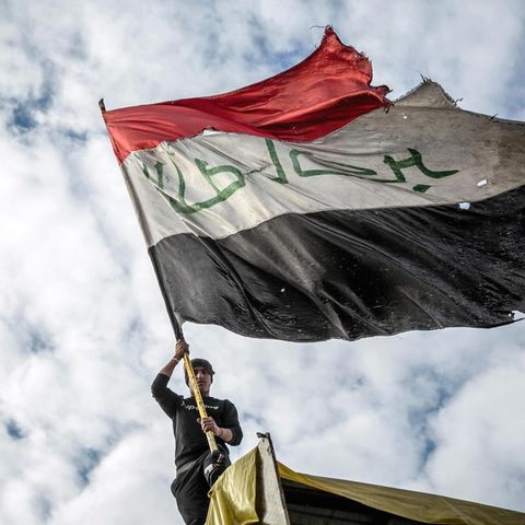 Ein Demonstrant schwenkt die irakische Flagge