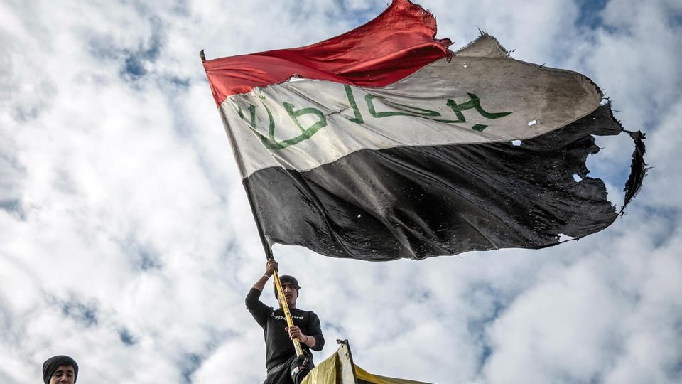 Ein Demonstrant schwenkt die irakische Flagge