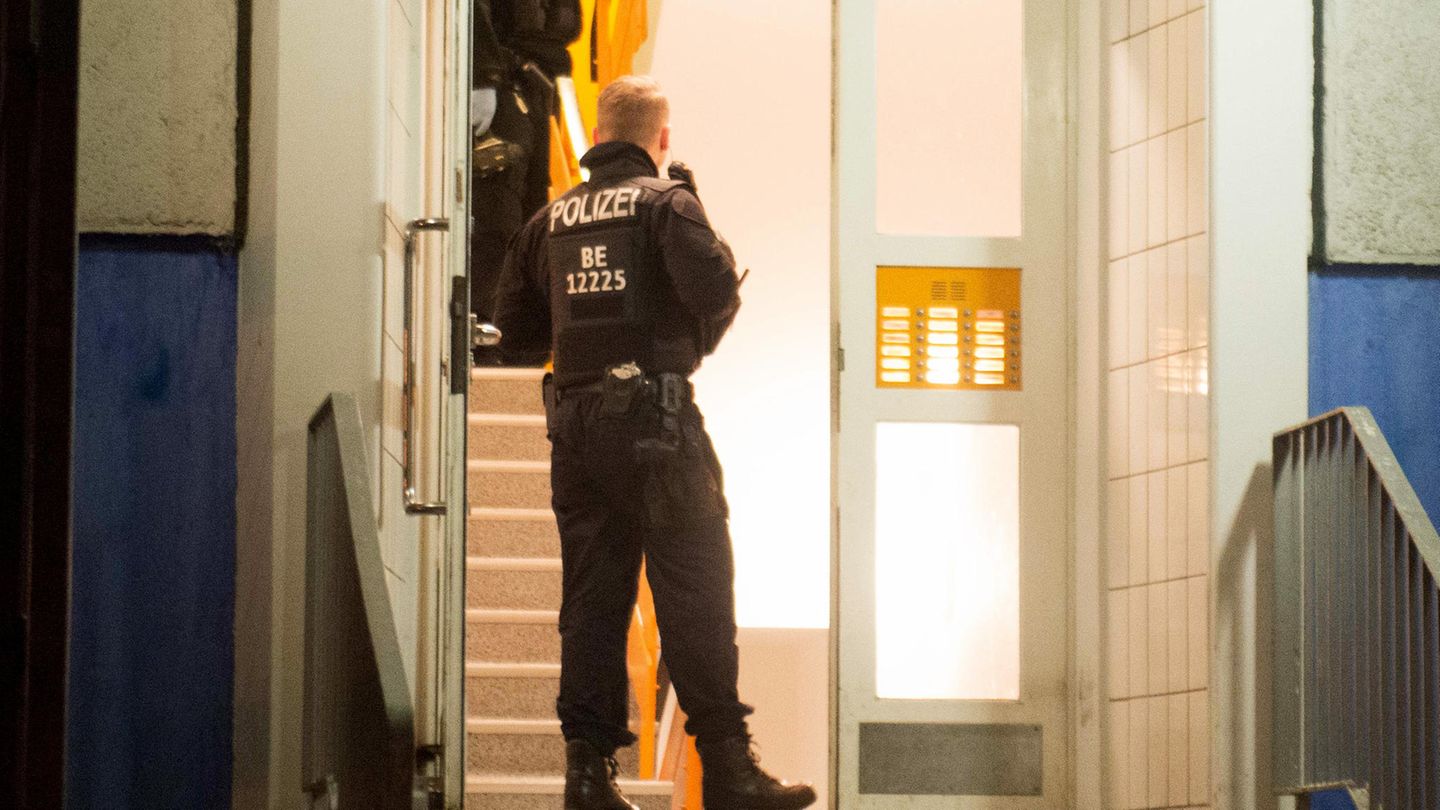Einsatzkräfte der Polizei stehen im Hausflur eines Mehrfamilienhauses in Marzahn-Hellersdorf