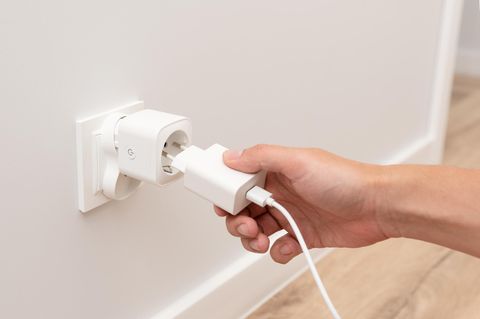 Man steckt das Ladegerät in die intelligente Steckdose