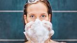 Frau wäscht sich die Haare