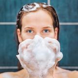 Frau wäscht sich die Haare