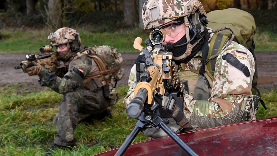 Ein Kampfschwimmer mit einem Maschinengewehr im Anschlag