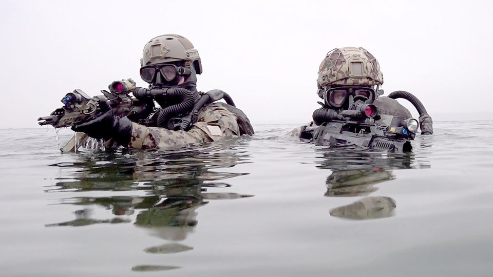 Kampfschwimmer gehen mit G36 Sturmgewehren bei einer Übung aus der Ostsee an Land Kampfschwimmer gehen mit G36 Sturmgewehren bei einer Übung aus der Ostsee an Land