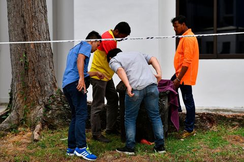 Die beiden Müllmänner zeigen Polizisten den Abfallbehälter, in dem sie das Baby gefunden haben