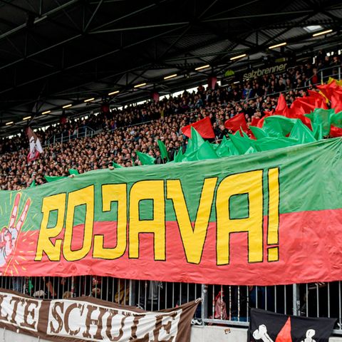 St. Pauli-Fans halten ein Banner mit dem Schriftzug "Biji Rojava" ("Es lebe Rojava") in die Höhe