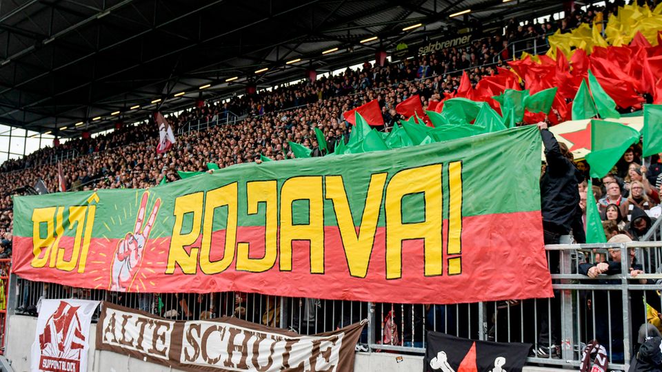 St. Pauli-Fans halten ein Banner mit dem Schriftzug "Biji Rojava" ("Es lebe Rojava") in die Höhe