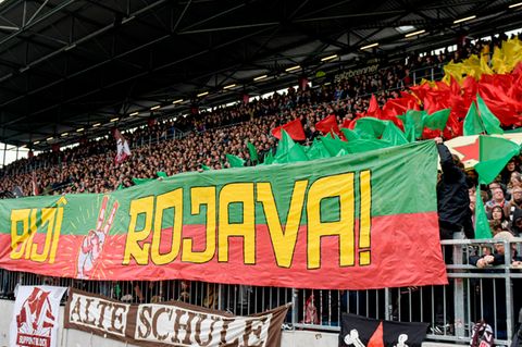 St. Pauli-Fans halten ein Banner mit dem Schriftzug "Biji Rojava" ("Es lebe Rojava") in die Höhe