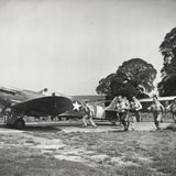 Piloten aus den USA laufen für die Kamera zu ihren Jägern vom Typ Supermarine Spitfire 5S.