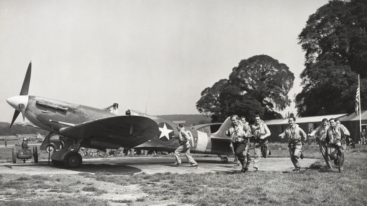 Piloten aus den USA laufen für die Kamera zu ihren Jägern vom Typ Supermarine Spitfire 5S.