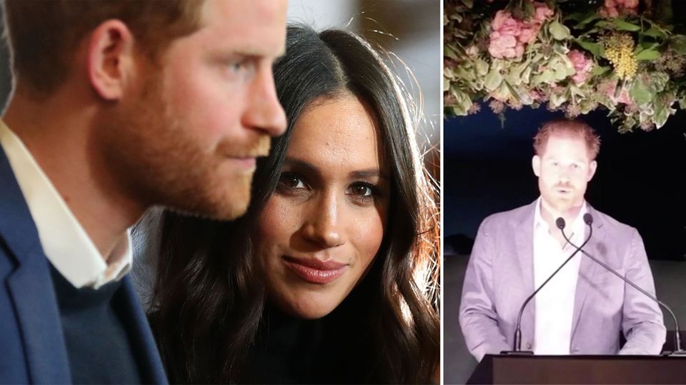 Prinz Harry steht an einem Pult und spricht in zwei Mikrofone. Über ihm eine Deko mit Blumen und Blättern
