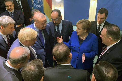 Bundeskanzlerin Angela Merkel steht mit anderen Regierungschefs in einem Kreis und gestikuliert