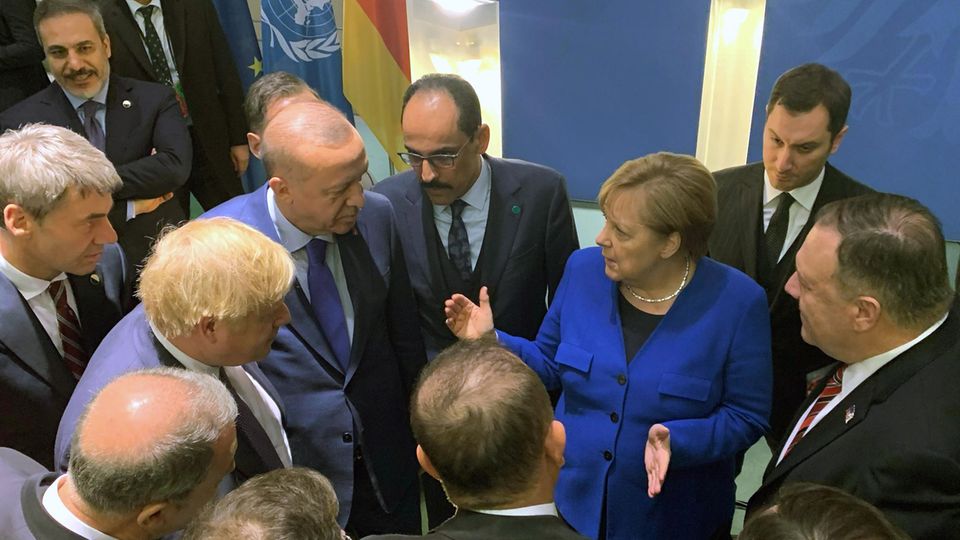 Bundeskanzlerin Angela Merkel steht mit anderen Regierungschefs in einem Kreis und gestikuliert