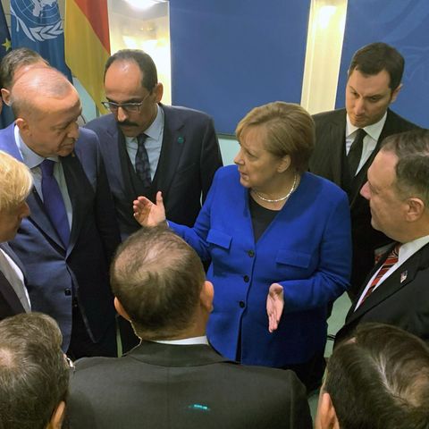 Bundeskanzlerin Angela Merkel steht mit anderen Regierungschefs in einem Kreis und gestikuliert