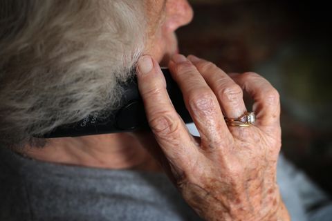 Eine ältere Frau telefoniert mit einem Festnetztelefon