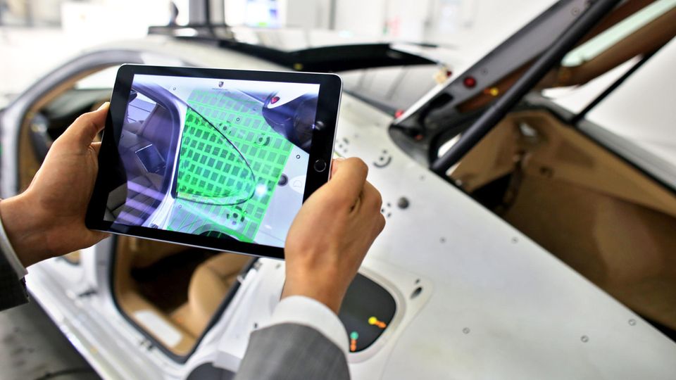 Ein Porsche-Ingenieur scannt mit einem Tablet ein Seitenteil eines Panamera auf Abweichungen - die Automobilindustrie ist bislang einer der Garanten für Deutschlands Status als Innovationsnation.