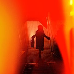 Rot-Orangefarbenes verschwommenes Bild mit den Umrissen einer Frau