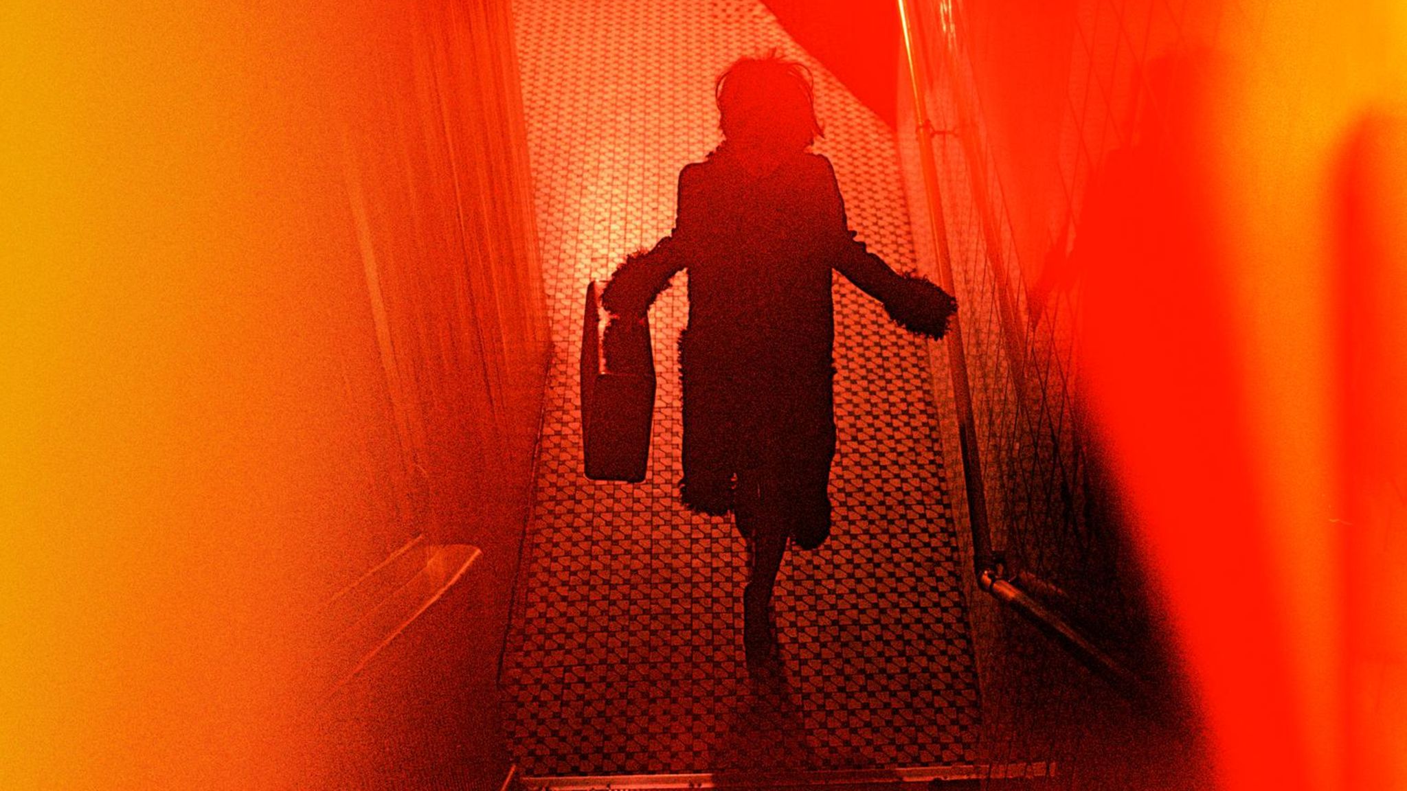 Rot-Orangefarbenes verschwommenes Bild mit den Umrissen einer Frau