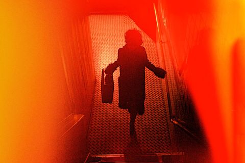 Rot-Orangefarbenes verschwommenes Bild mit den Umrissen einer Frau