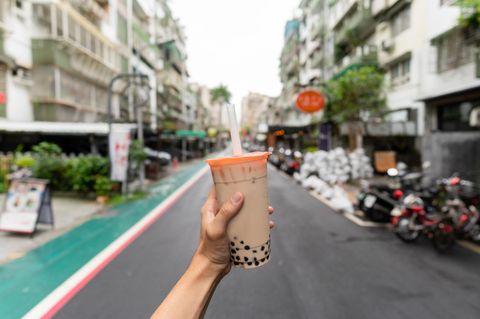 Eine Hand hält einen Plastikbecher mit Bubble Tea
