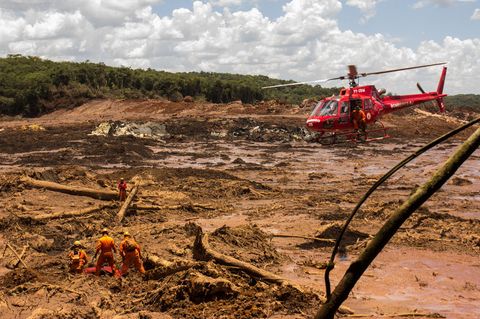 29.01.2019, Brasilien, Brumadinho: Feuerwehrleute bergen mit Hilfe eines Hubschraubers eine Leiche
