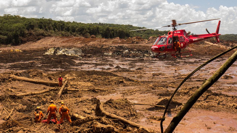 29.01.2019, Brasilien, Brumadinho: Feuerwehrleute bergen mit Hilfe eines Hubschraubers eine Leiche