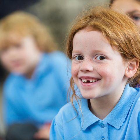 Kinder in blauen Schuluniformen in einer Klasse