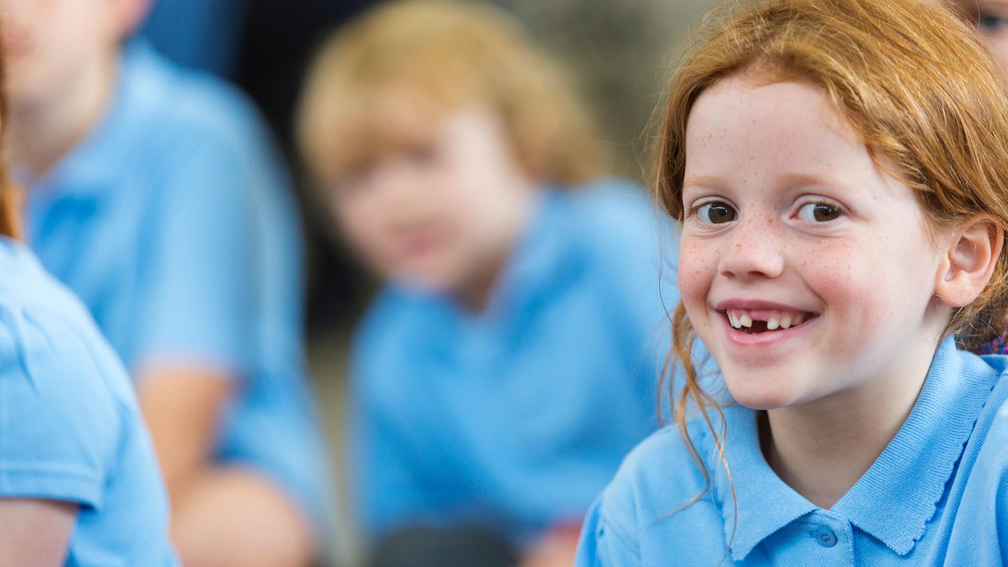Kinder in blauen Schuluniformen in einer Klasse
