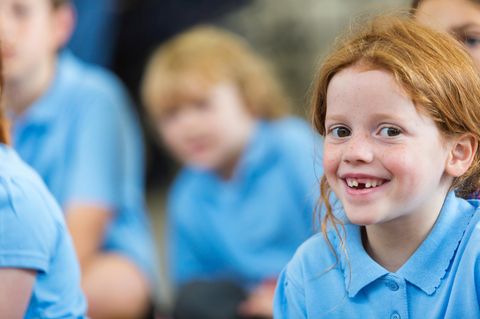 Kinder in blauen Schuluniformen in einer Klasse