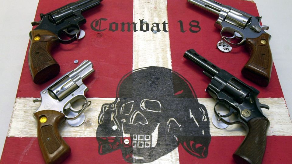 Sichergestellte Waffen und ein Schild der kriminellen Neonazi-Gruppe "Combat 18" (Archiv) Sichergestellte Waffen und ein Schild der kriminellen Neonazi-Gruppe "Combat 18" (Archiv)