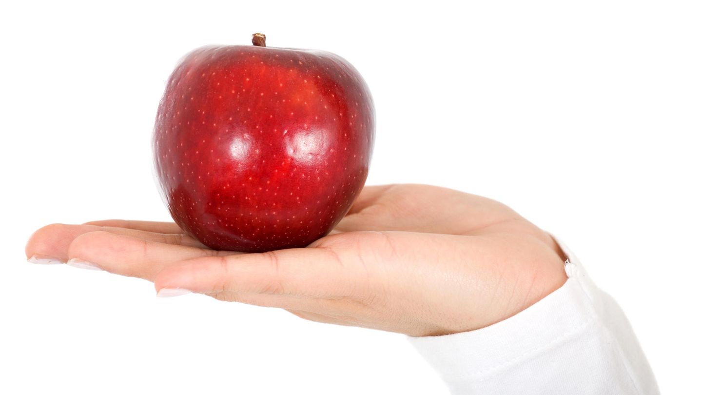 Diäten im stern-Check: Frau hält roten Apfel in der Hand